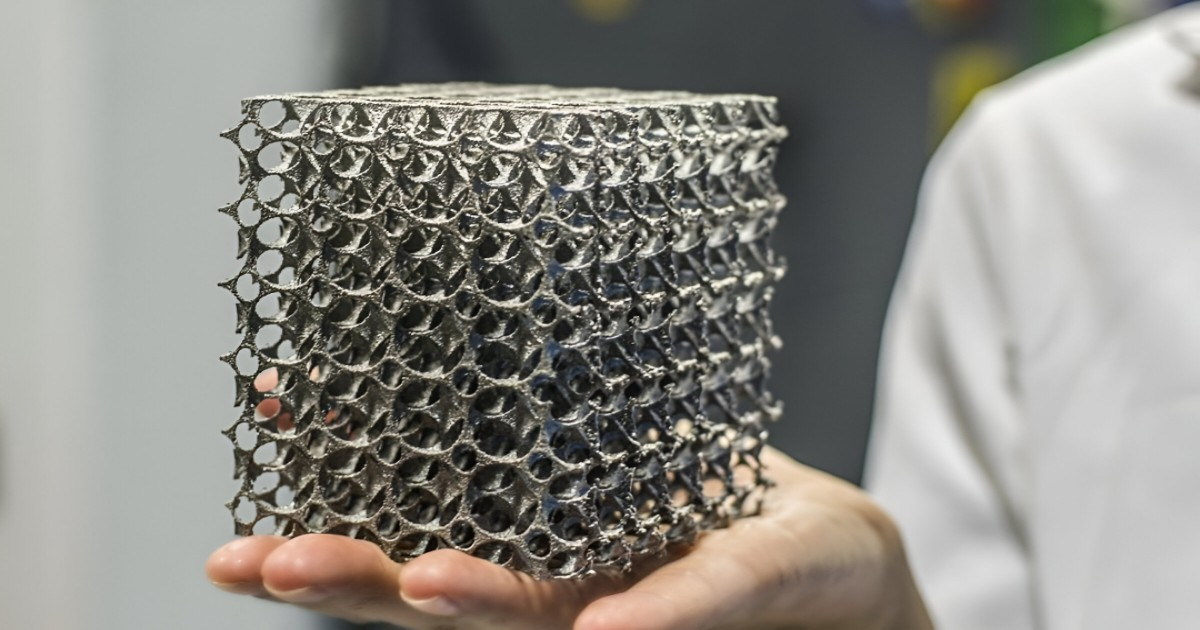  A person holds a metal mesh cube, showcasing the precision of metal 3D printing services.