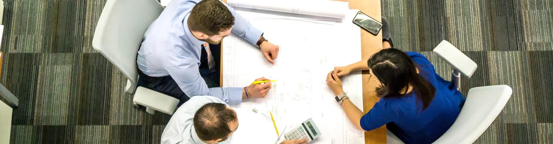 Group of professionals discussing project details at a meeting table.